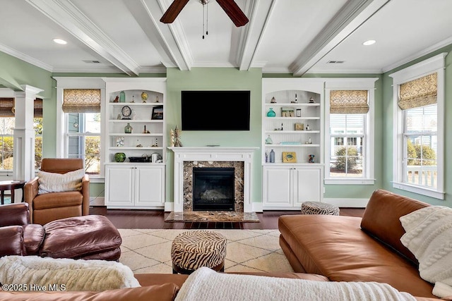 living room featuring a high end fireplace, crown molding, beamed ceiling, ceiling fan, and dark hardwood / wood-style floors