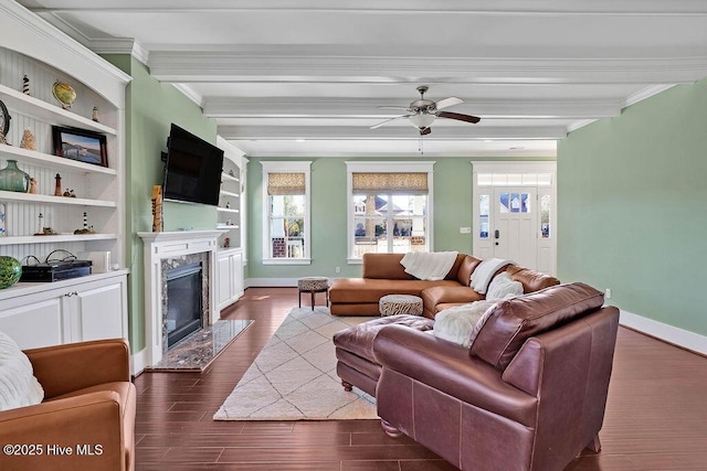 living room featuring a high end fireplace, crown molding, ceiling fan, beam ceiling, and built in shelves