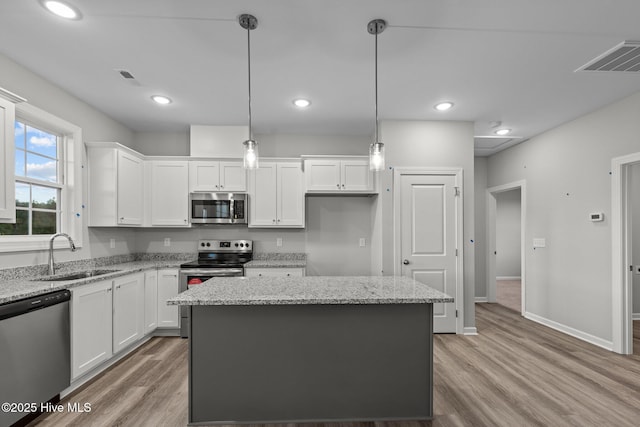 kitchen with white cabinets, pendant lighting, stainless steel appliances, and sink