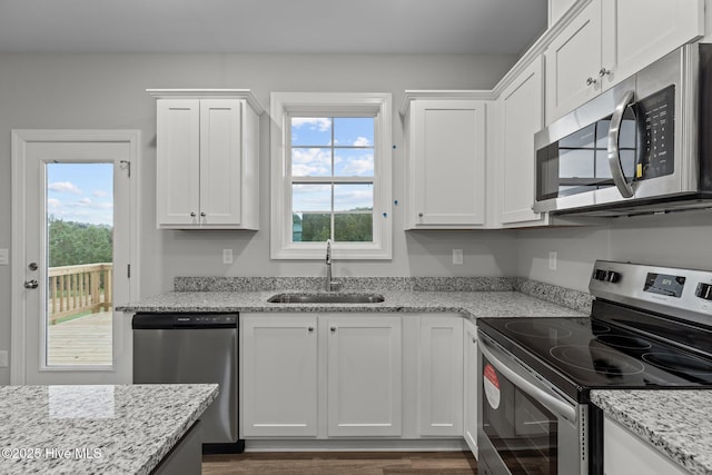 kitchen featuring white cabinets, sink, a healthy amount of sunlight, light stone counters, and stainless steel appliances