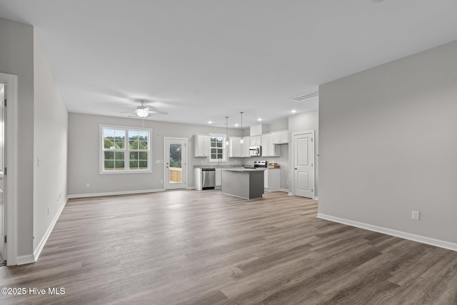 unfurnished living room with hardwood / wood-style flooring and ceiling fan