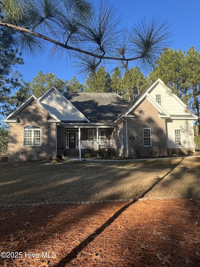 ranch-style house with covered porch and a front lawn