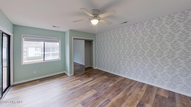 unfurnished bedroom with ceiling fan, a closet, and hardwood / wood-style flooring