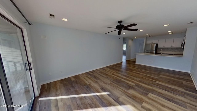 unfurnished living room with hardwood / wood-style floors, ceiling fan, and sink