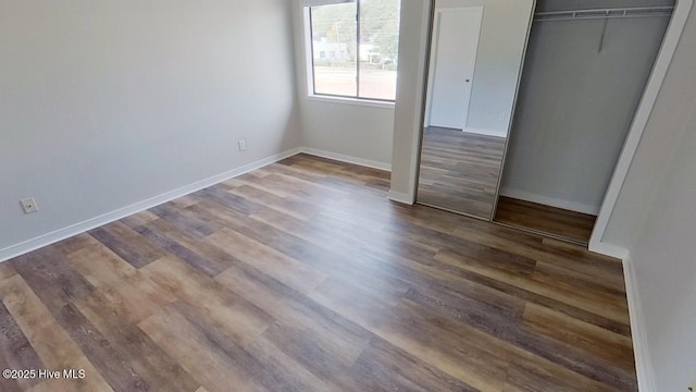 unfurnished bedroom featuring dark hardwood / wood-style flooring and a closet