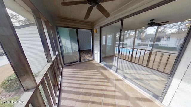 unfurnished sunroom with ceiling fan