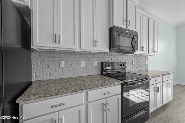 kitchen featuring light stone counters, crown molding, white cabinets, and black appliances