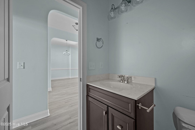 bathroom with hardwood / wood-style floors, vanity, and toilet