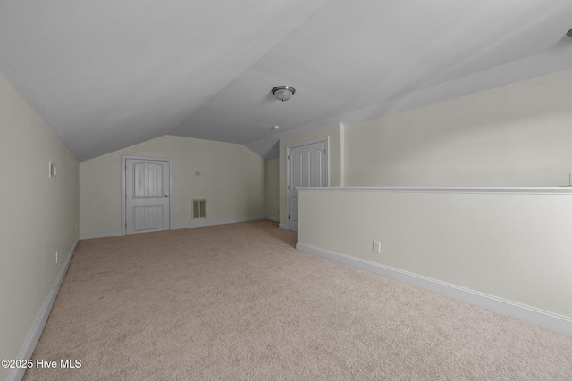 additional living space with light carpet and vaulted ceiling