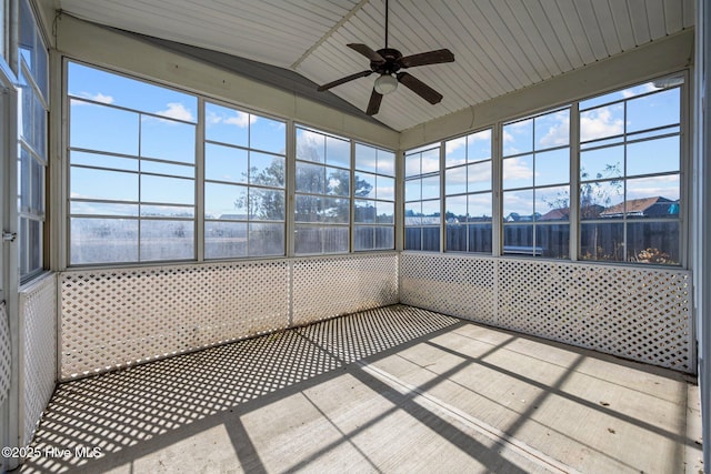 unfurnished sunroom featuring ceiling fan, a healthy amount of sunlight, and vaulted ceiling