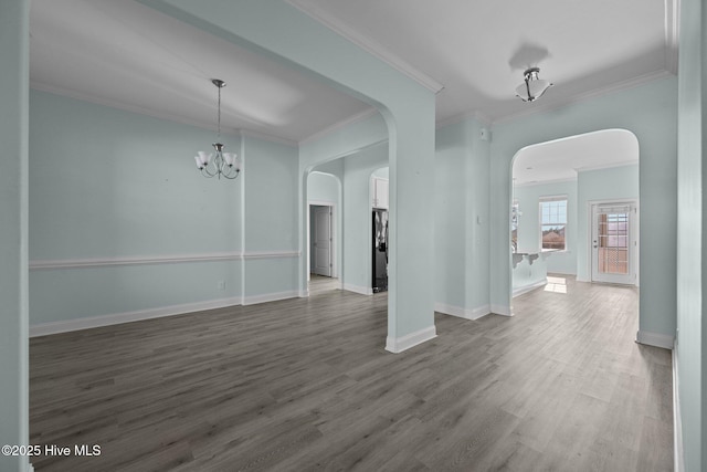 interior space with an inviting chandelier, ornamental molding, and hardwood / wood-style flooring