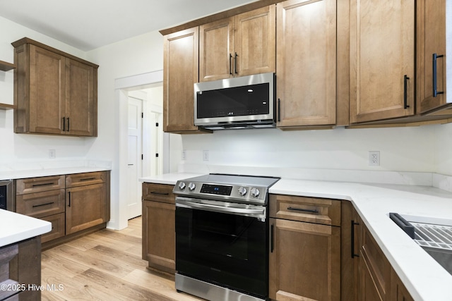 kitchen featuring appliances with stainless steel finishes and light hardwood / wood-style flooring