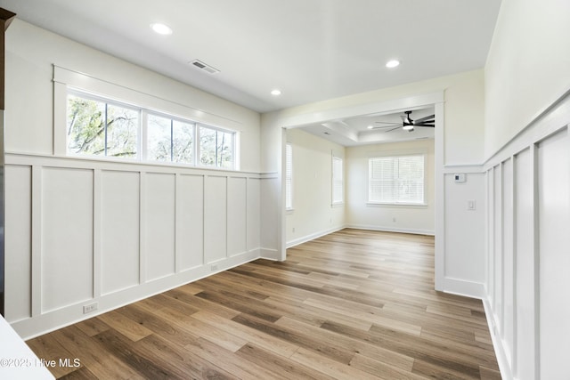 unfurnished room featuring ceiling fan, a healthy amount of sunlight, and light wood-type flooring