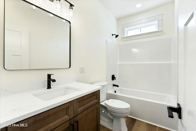 full bathroom with washtub / shower combination, wood-type flooring, vanity, and toilet