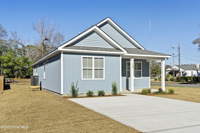 view of front of house with covered porch, central AC, and a front yard