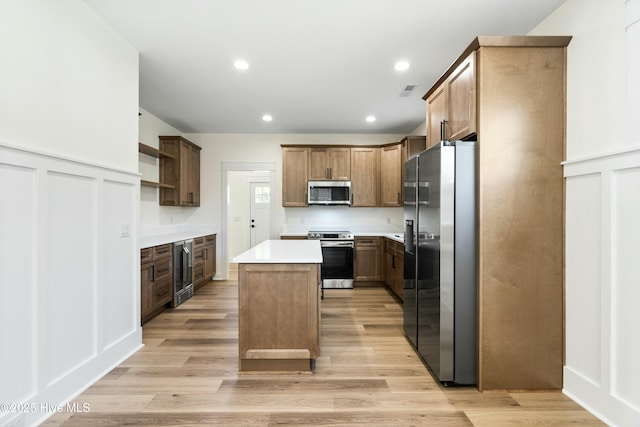 kitchen with wine cooler, a center island, light wood-type flooring, and appliances with stainless steel finishes