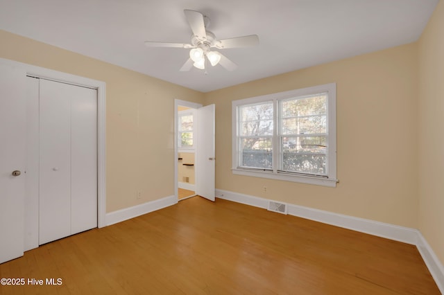 unfurnished bedroom featuring ceiling fan, wood-type flooring, and a closet