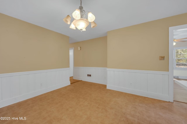 empty room with light carpet and ceiling fan with notable chandelier