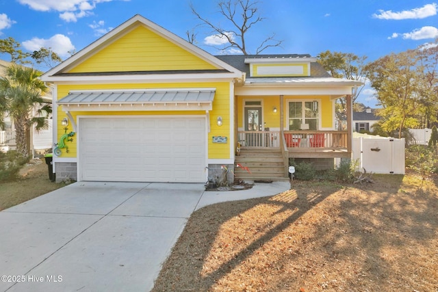 view of front facade with covered porch, concrete driveway, an attached garage, and fence