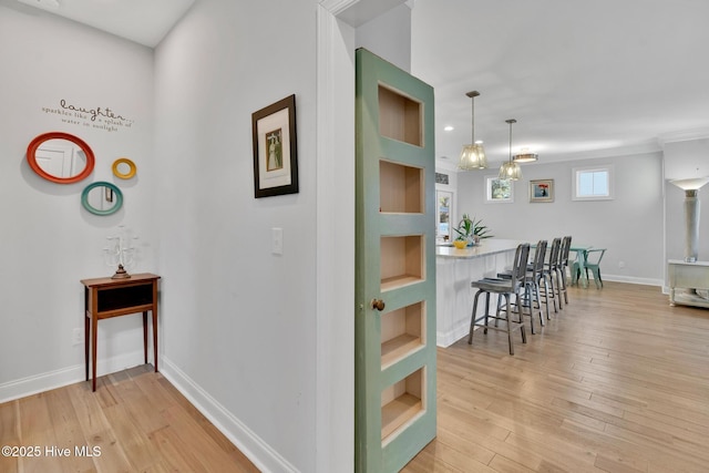 corridor with baseboards and light wood-style floors