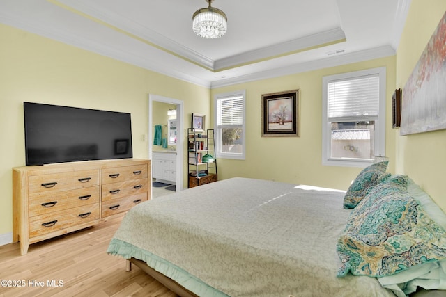 bedroom featuring light hardwood / wood-style flooring, a raised ceiling, and crown molding