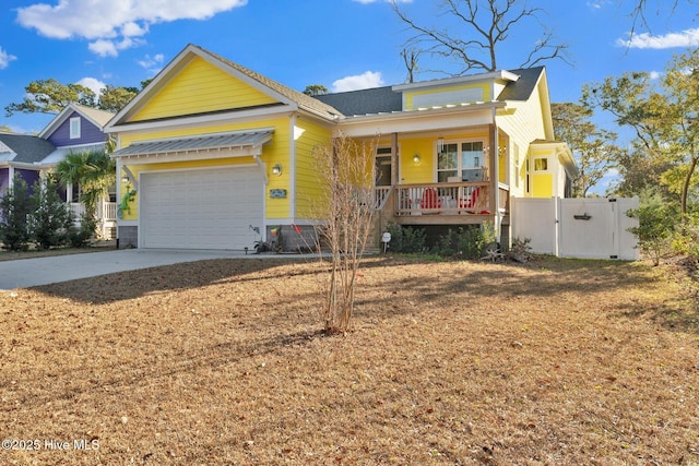 view of front of house with fence, concrete driveway, covered porch, an attached garage, and a gate