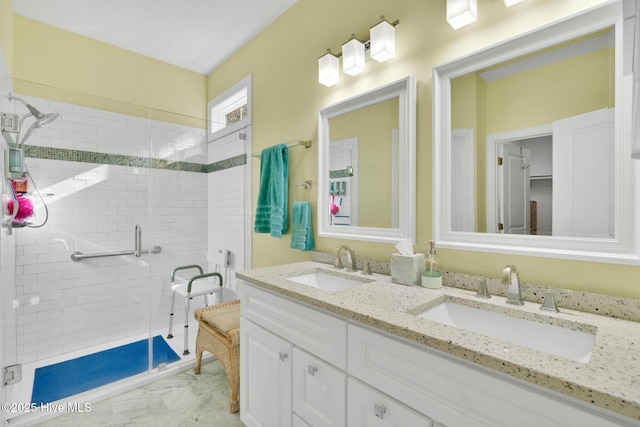 bathroom with a sink, double vanity, and a shower stall