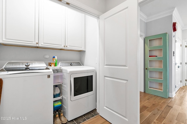 washroom featuring crown molding, independent washer and dryer, cabinets, and light wood-type flooring