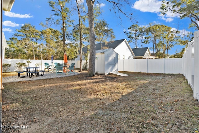 view of yard featuring a shed, a patio area, a fenced backyard, and an outdoor structure