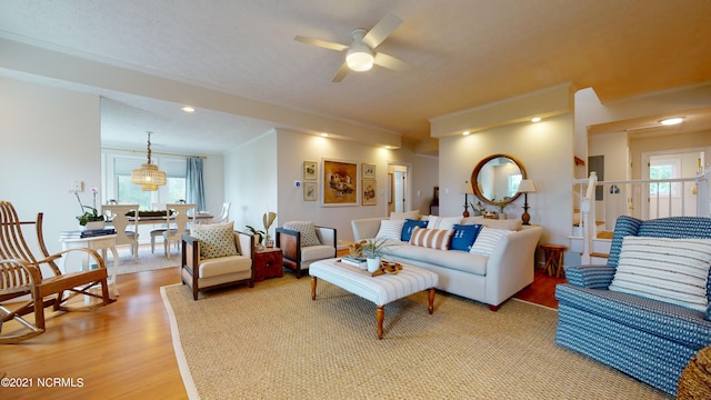 living room featuring ceiling fan, wood-type flooring, and a textured ceiling