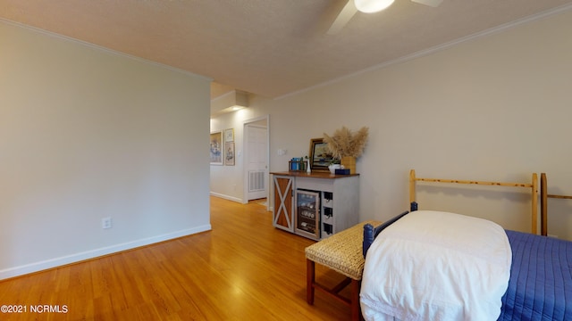 bedroom with hardwood / wood-style floors, ceiling fan, and crown molding