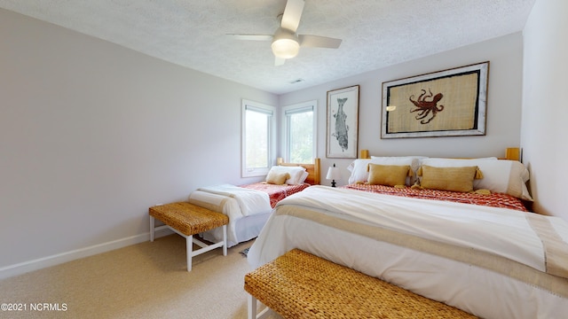 carpeted bedroom with ceiling fan and a textured ceiling