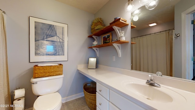 bathroom with tile patterned floors, vanity, a textured ceiling, and toilet