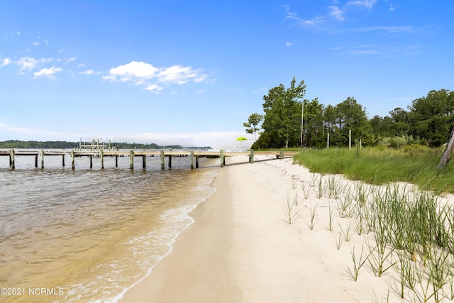 property view of water with a beach view and a boat dock