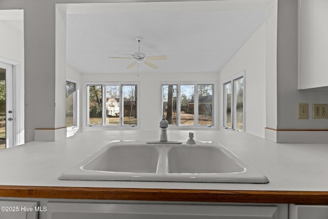 kitchen with ceiling fan, lofted ceiling, and sink