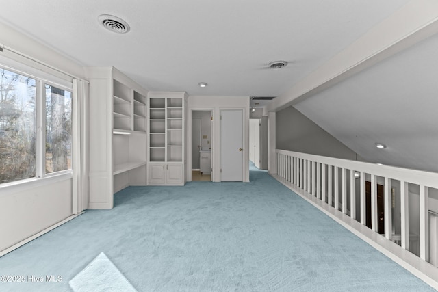 additional living space with carpet, a healthy amount of sunlight, and vaulted ceiling