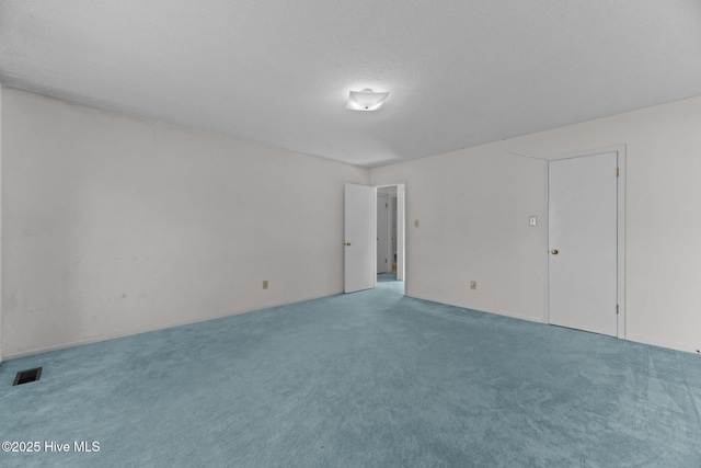 empty room with a textured ceiling and carpet flooring