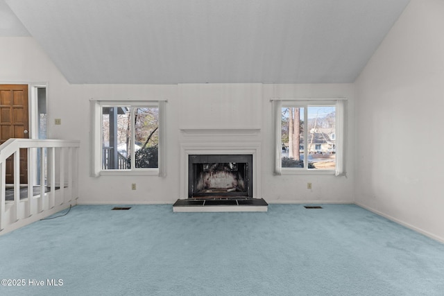 unfurnished living room featuring carpet floors and vaulted ceiling