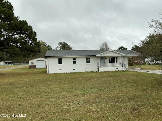 view of front facade with a porch, a garage, an outbuilding, and a front yard