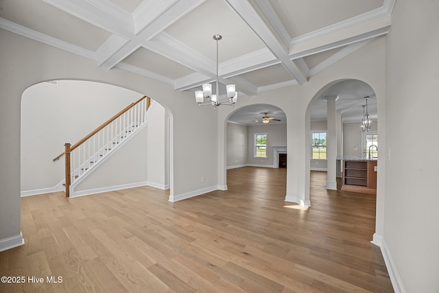 unfurnished dining area featuring coffered ceiling, hardwood / wood-style floors, beamed ceiling, and ceiling fan with notable chandelier