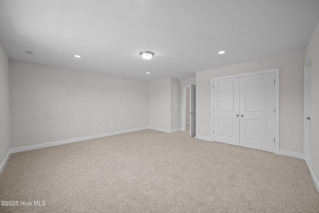 unfurnished bedroom with light carpet and a closet