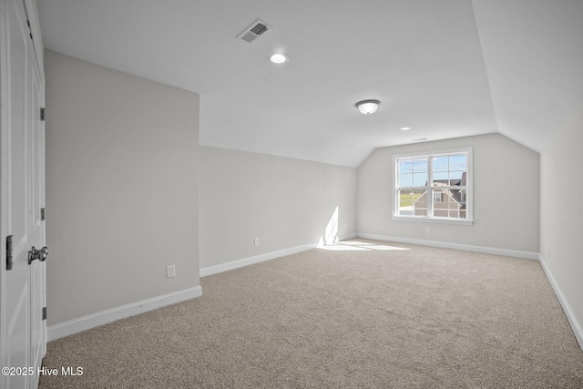 additional living space featuring carpet and vaulted ceiling