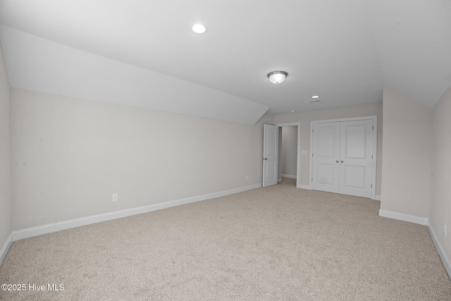 bonus room featuring light colored carpet and vaulted ceiling