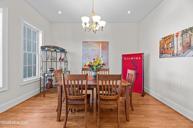 dining area featuring hardwood / wood-style flooring and a notable chandelier