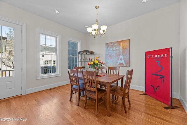 dining room with a notable chandelier and light hardwood / wood-style flooring