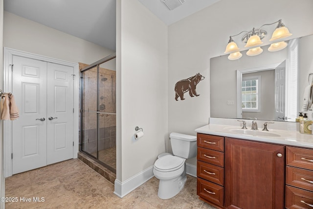 bathroom with a shower with shower door, vanity, and toilet