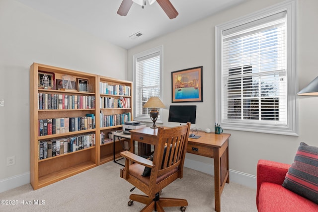 carpeted office space with ceiling fan