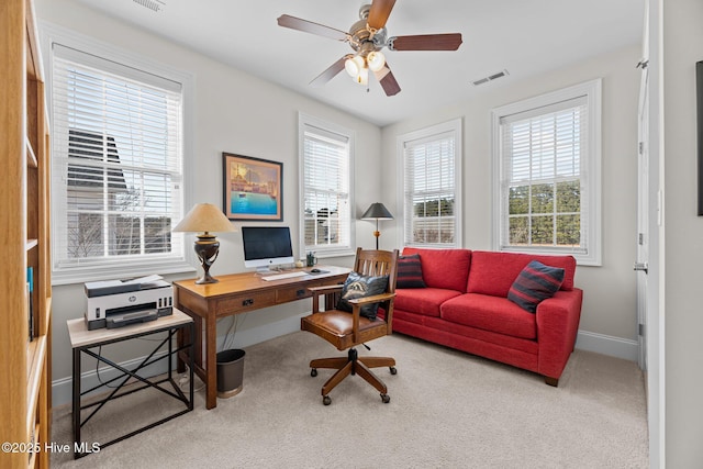 carpeted office space featuring ceiling fan and plenty of natural light