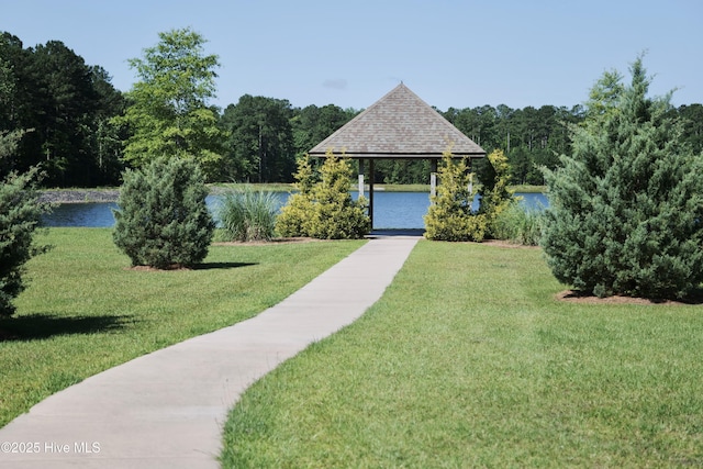 view of community featuring a water view, a gazebo, and a lawn