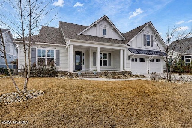 view of front of property with covered porch, a garage, and a front yard